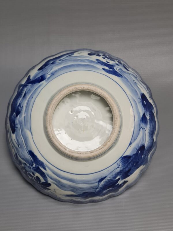 A Japanese blue-white pleated porcelain bowl with a decor of carp and a botanical decor in the middle, 18th century - Afbeelding 4